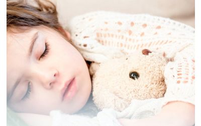 Young child asleep with a teddy