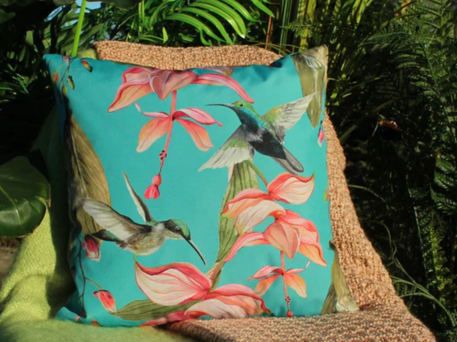 Evans Lichfield Hummingbird blue outdoor cushion on garden furniture